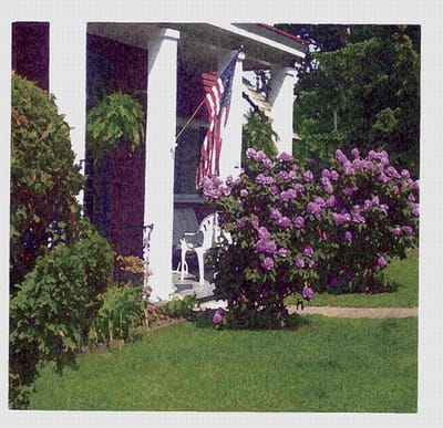 Exterior view of a facility with flowers and an American flag