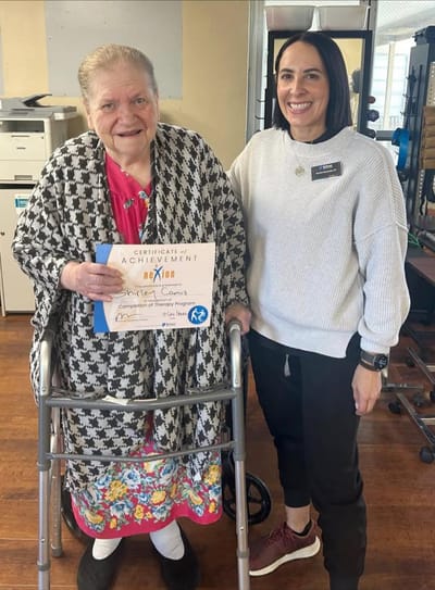 Resident receiving an achievement certificate with staff member