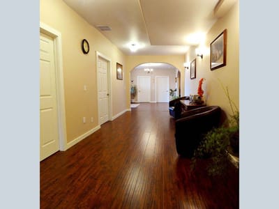 Bright indoor hallway with wooden flooring and artwork