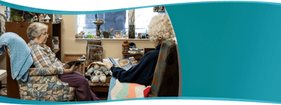 Two residents reading in a cozy common area