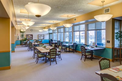 Bright dining room with tables and chairs set up