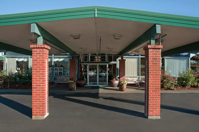 Covered entrance of Life Care Center with flower pots