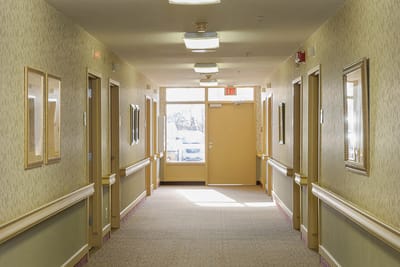 Well-lit hallway in a nursing home facility