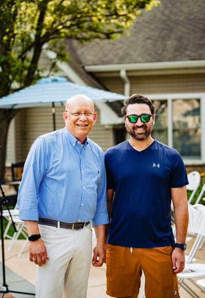 Two men posing outdoors at a senior healthcare facility