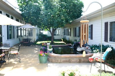 Serene outdoor courtyard with a wind chime and greenery
