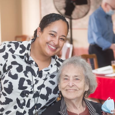 A resident and staff member smiling together