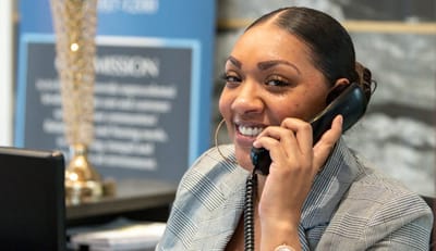 Staff member at reception desk speaking on the phone