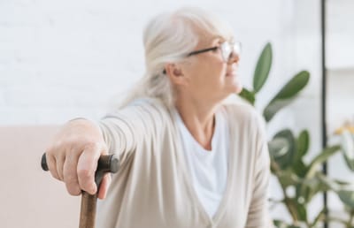 Senior woman with a cane in a bright interior