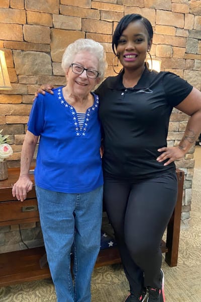 Resident and staff member smiling together