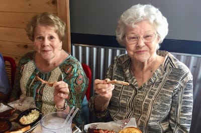 Two senior women enjoying a meal together