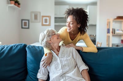 A caregiver interacting with a senior resident in a cozy living room