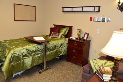 Cozy resident room with green bedding and furnishings