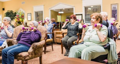 Residents participating in a light exercise class indoors