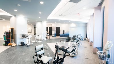 A well-lit rehabilitation gym with exercise equipment
