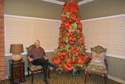 Resident reading near a decorated Christmas tree
