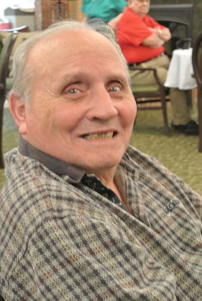 A smiling resident in a common area of the facility