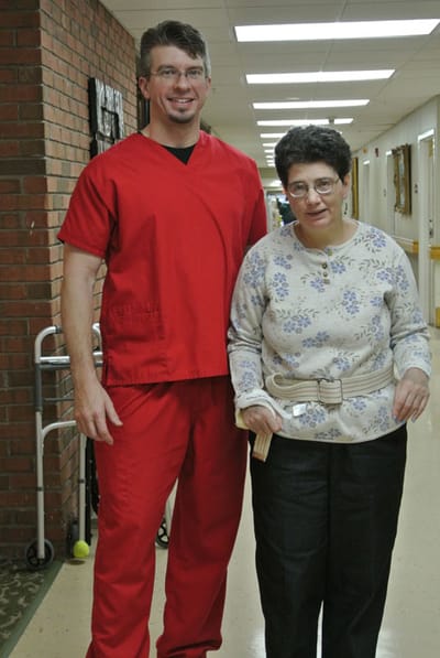 Staff member assisting a resident in a hallway