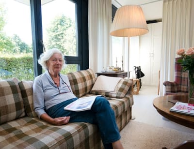 Resident sitting comfortably in a cozy lounge area