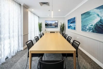 Bright common area with a long table and artwork