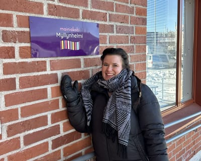 Person posing by the Mainiokoti Myllynhelmi sign