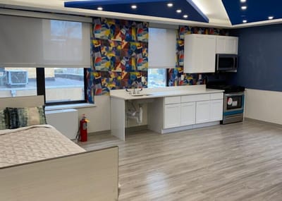 Bright interior room with kitchen area and colorful wall art
