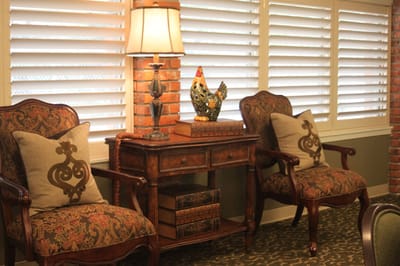 Cozy lounge area with plush chairs and a lamp