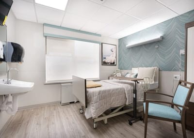 A private resident room with a hospital bed and seating