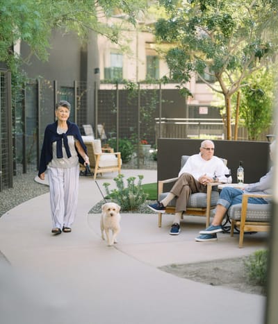 Residents enjoying a walk in the outdoor space with a dog