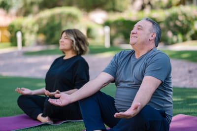 Two residents practicing yoga outdoors