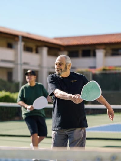Elderly men playing tennis outdoors
