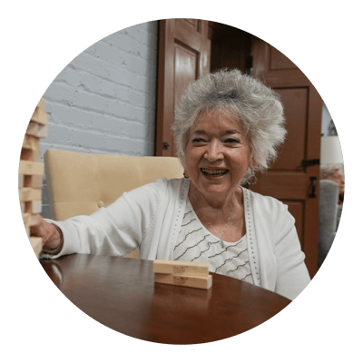 Resident enjoying a game of Jenga in a cozy interior setting