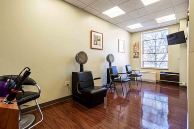Interior salon area with styling chairs and a window