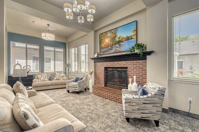 Bright common area with cozy seating and a fireplace