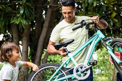 A man and child with a bicycle outdoors