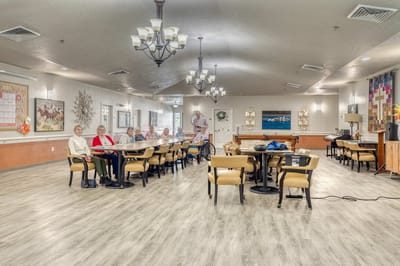 Residents socializing in a common area with tables and chairs
