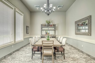 Well-lit dining room with a large table and chairs
