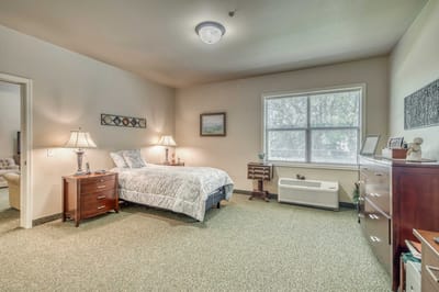 A cozy private resident room with a bed and furniture