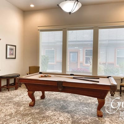 Interior game room with a pool table and sunlight