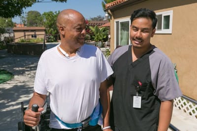 A resident and staff member interacting outdoors
