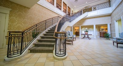 Interior view of a facility's lobby with a grand staircase