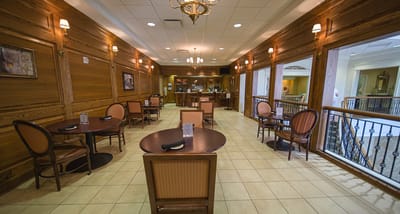 Common area with dining tables and wooden decor.