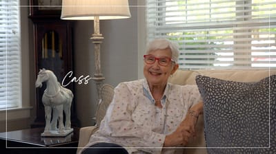 A joyful senior resident smiling in a cozy living room