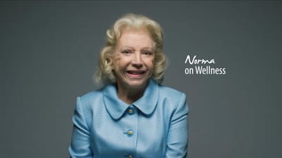 Older woman smiling in a light blue blouse