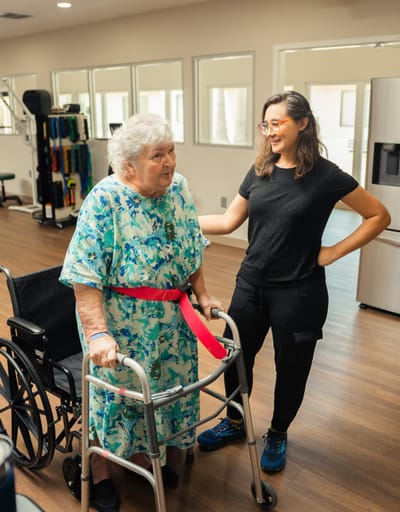 A staff member assisting a resident in a rehab center