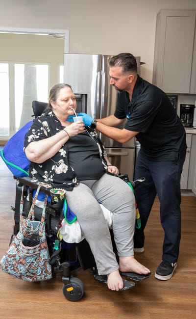Staff assisting a resident with nourishment in a care setting