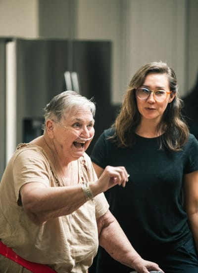 An elderly woman laughing with a staff member