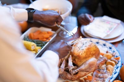 Residents enjoying a meal with a roast turkey