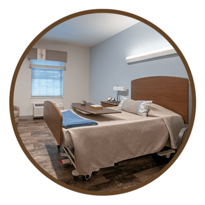 A well-furnished resident room with a hospital bed