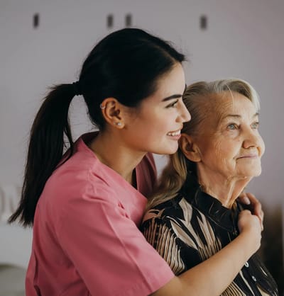 Staff member embracing a resident in a bright common area
