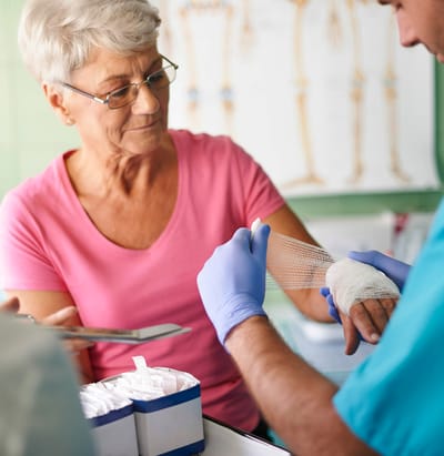 Nurse assisting a resident with a bandaged hand